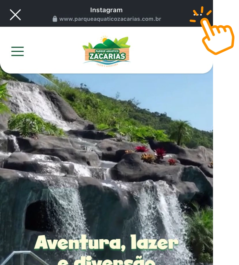 Print da tela do site aberto no navegador do Instagram. No topo superior direito tem um ícone de clique sobre os três pontinhos, indicando o local a ser clicado.